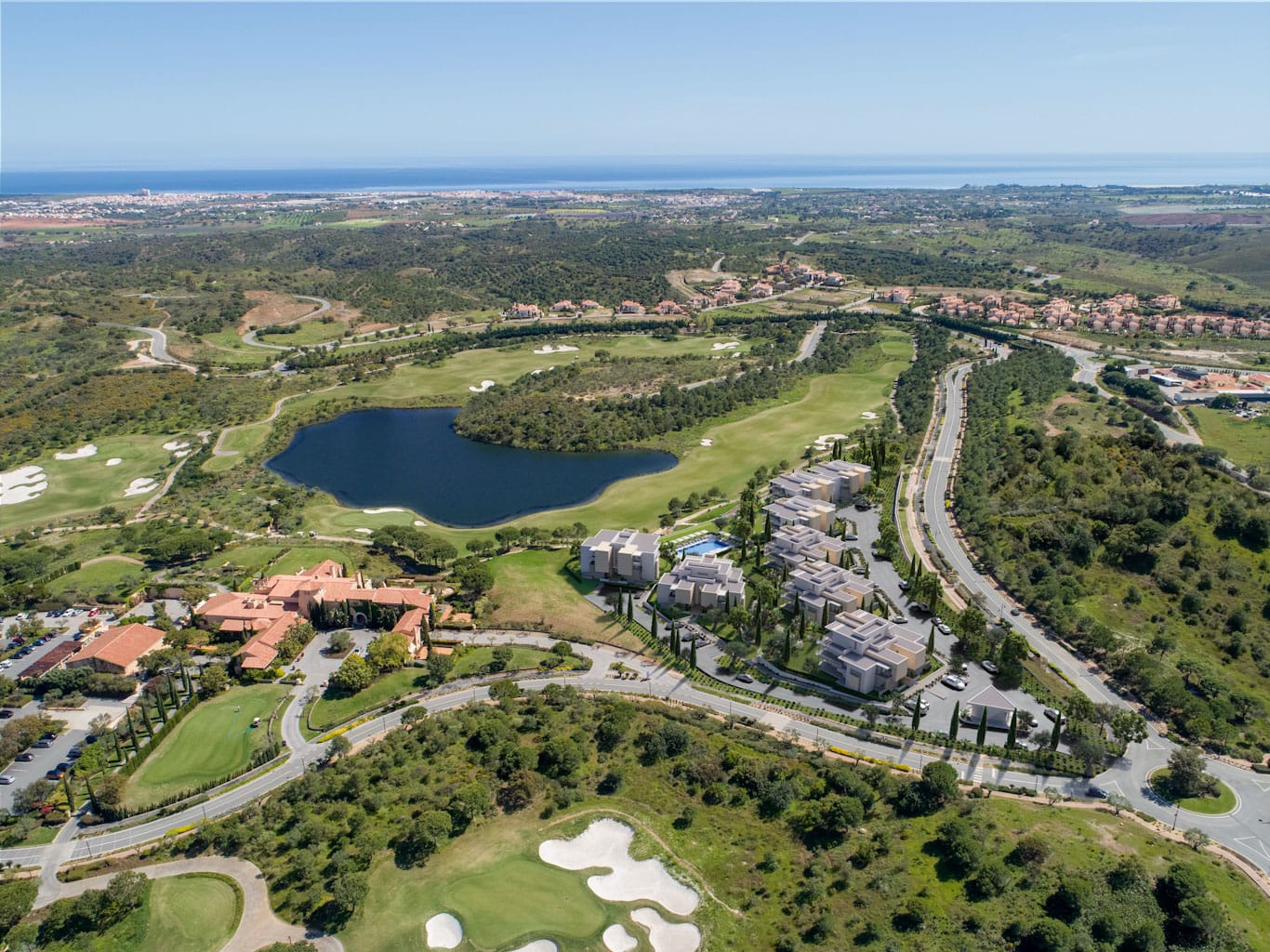 Aerial view of Algarve golf resort with lake, fairways and Atlantic Ocean in the background